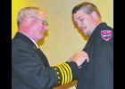 Dell Cerny (left) puts the President’s badge on incoming NSVFA President Justin Scamehorn.