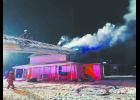 Ashland firefighters access the roof of a home on fire by using the aerial ladder due to icy conditions. While fighting the fire, a marijuana grow operation was discovered in the house and one person was arrested. Photo by Tiffany Alcorn, Ashland Rescue.	