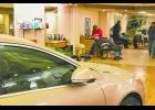 Hair dresser returned to rins-ing a customer’s hair (top pho-to) as Grinnell Fire Chief Dan Sicard talks with the driver of the vehicle and one employee of 1st Impressions in the back of the salon. Photo courtesy of Dann Hayes.
